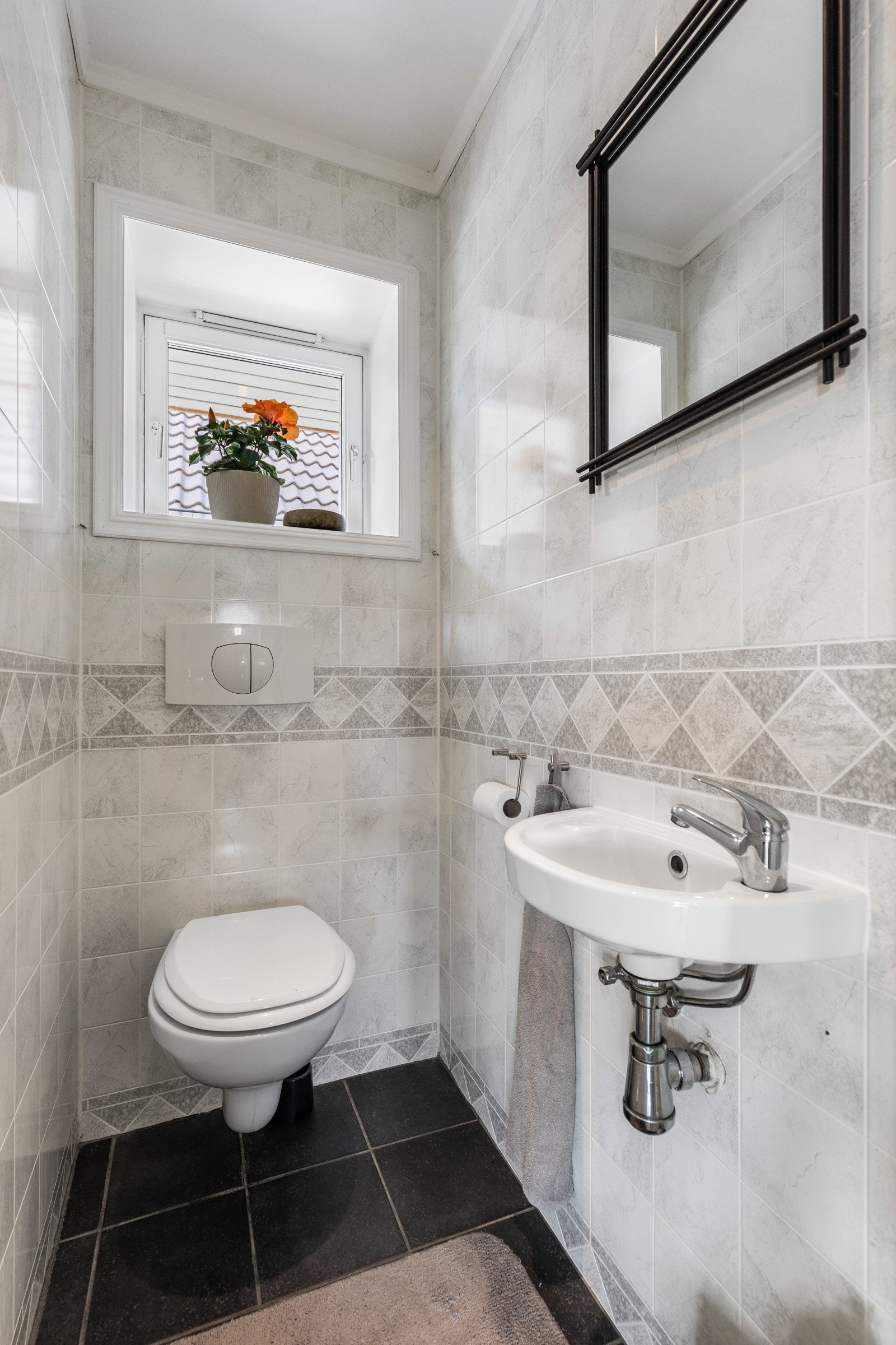 Boligen har et helfliset wc-rom med speil, enkel servant og vegghengt toalett. Galleribilde