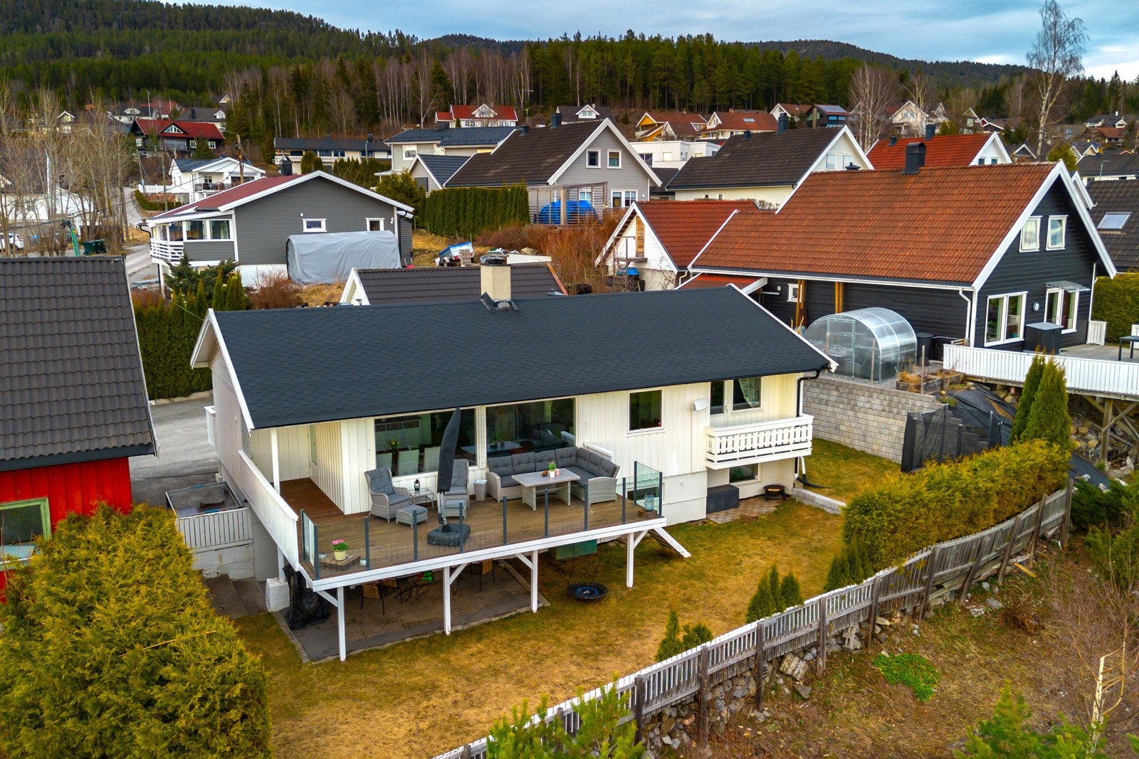 Tomten er opparbeidet med gressplen på nedsiden, og på inngangssiden har boligen en asfaltert gårdsplass med hekk og stor garasje. Galleribilde