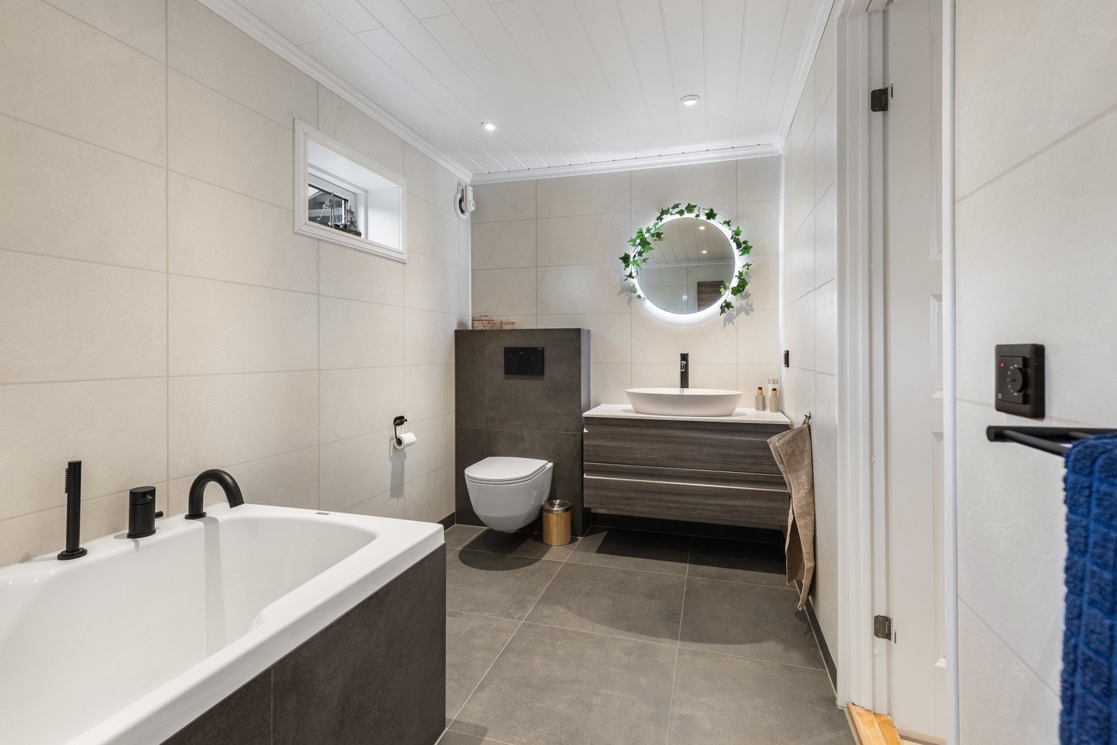 Downlights og varmekabler er installert, og badet har vegghengt toalett og et deilig, innfliset badekar med dusjløsning. Galleribilde