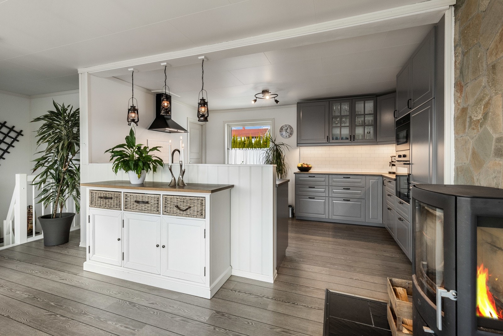 Innredningen har grå, profilerte fronter, vitrineskap og laminert benkeplate med sort oppvaskkum. Galleribilde