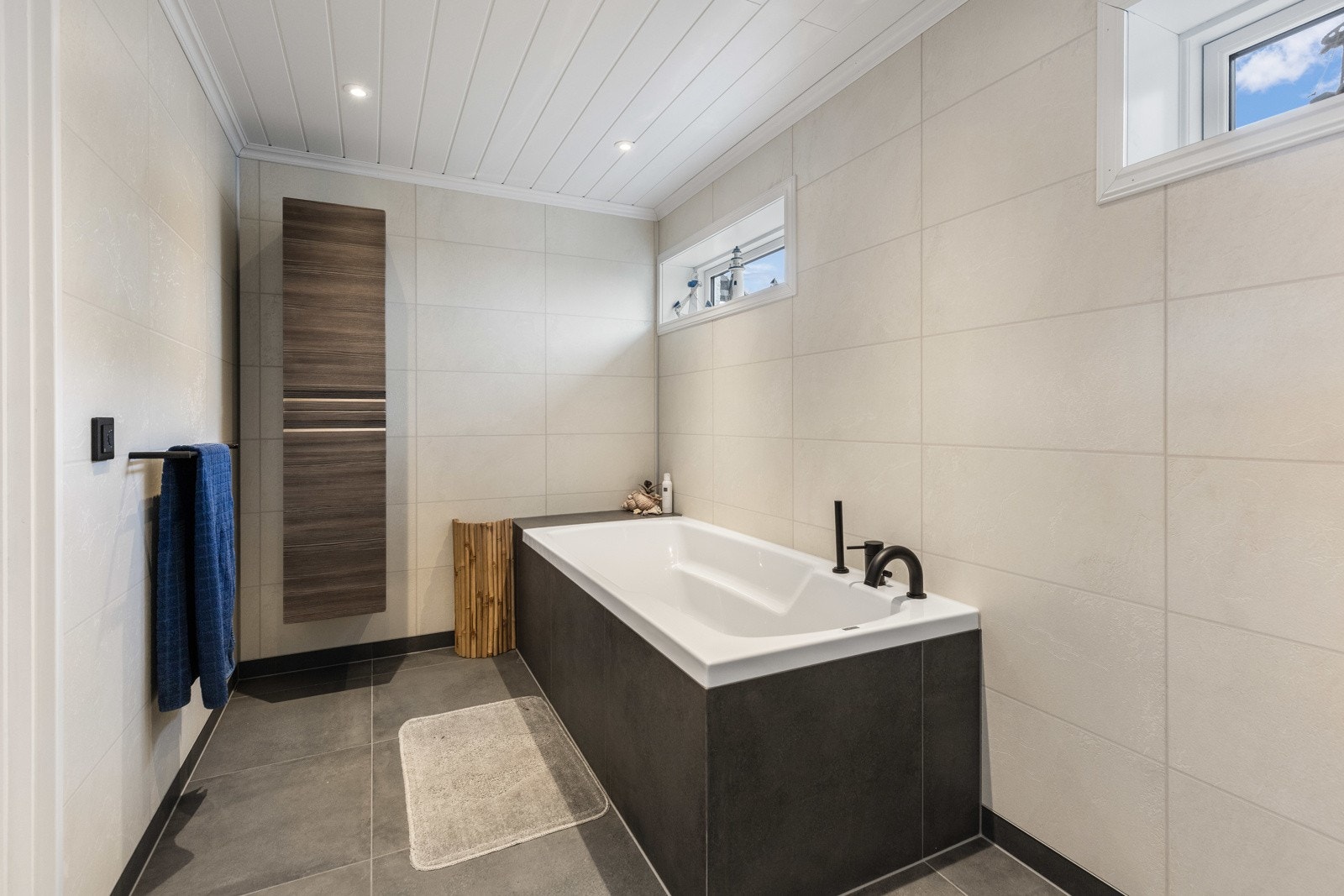 Badet nede ble pusset opp i 2022, og har et delikat uttrykk med store, grå gulvfliser og lyse våtromsplater i flismønster. Galleribilde