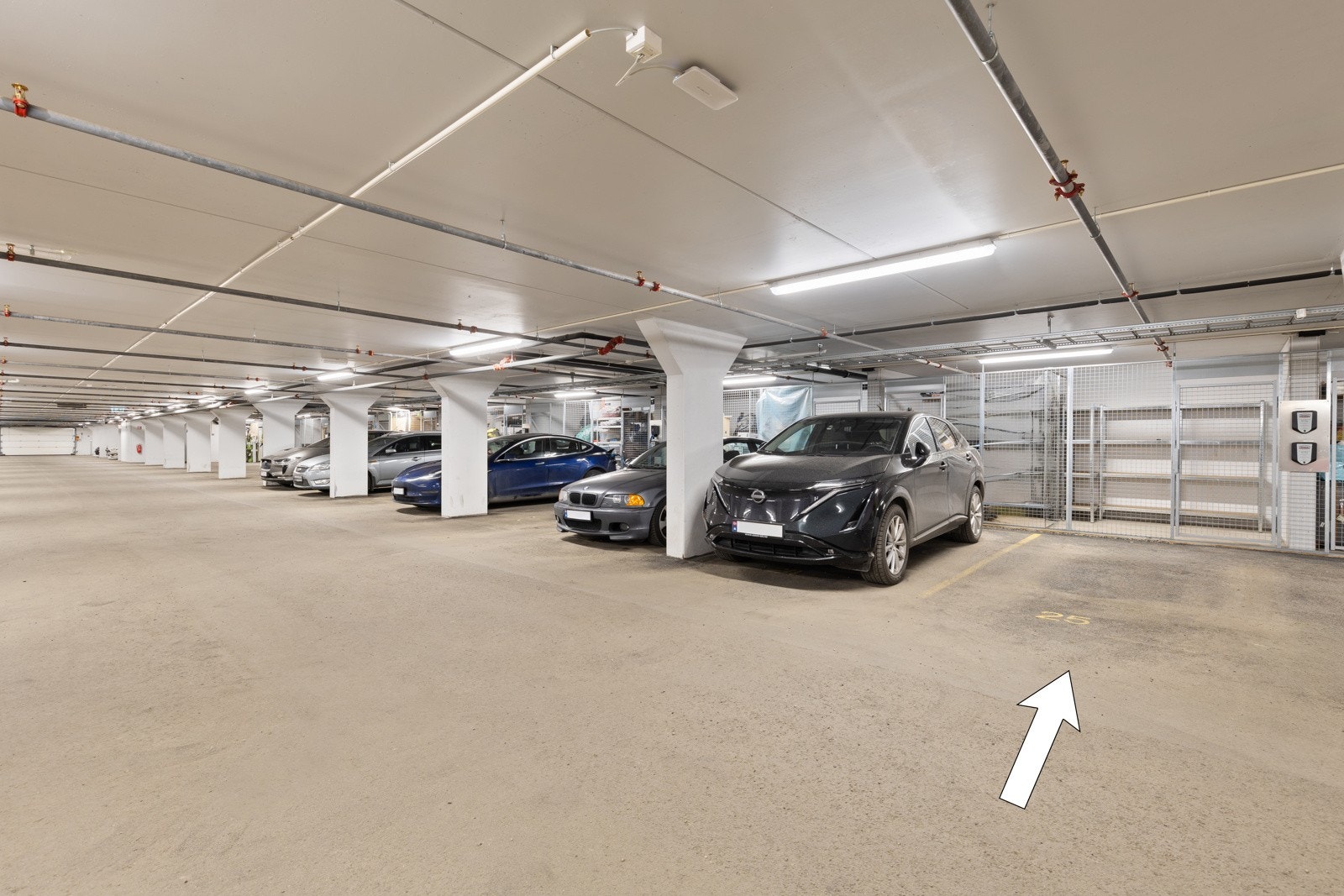Leiligheten har en fast garasjeplass i felles garasjeanlegg i kjeller med heis direkte til etasjeplan. Det er etablert sportsbod på ca. 5 kvm i bakkant av denne. Galleribilde