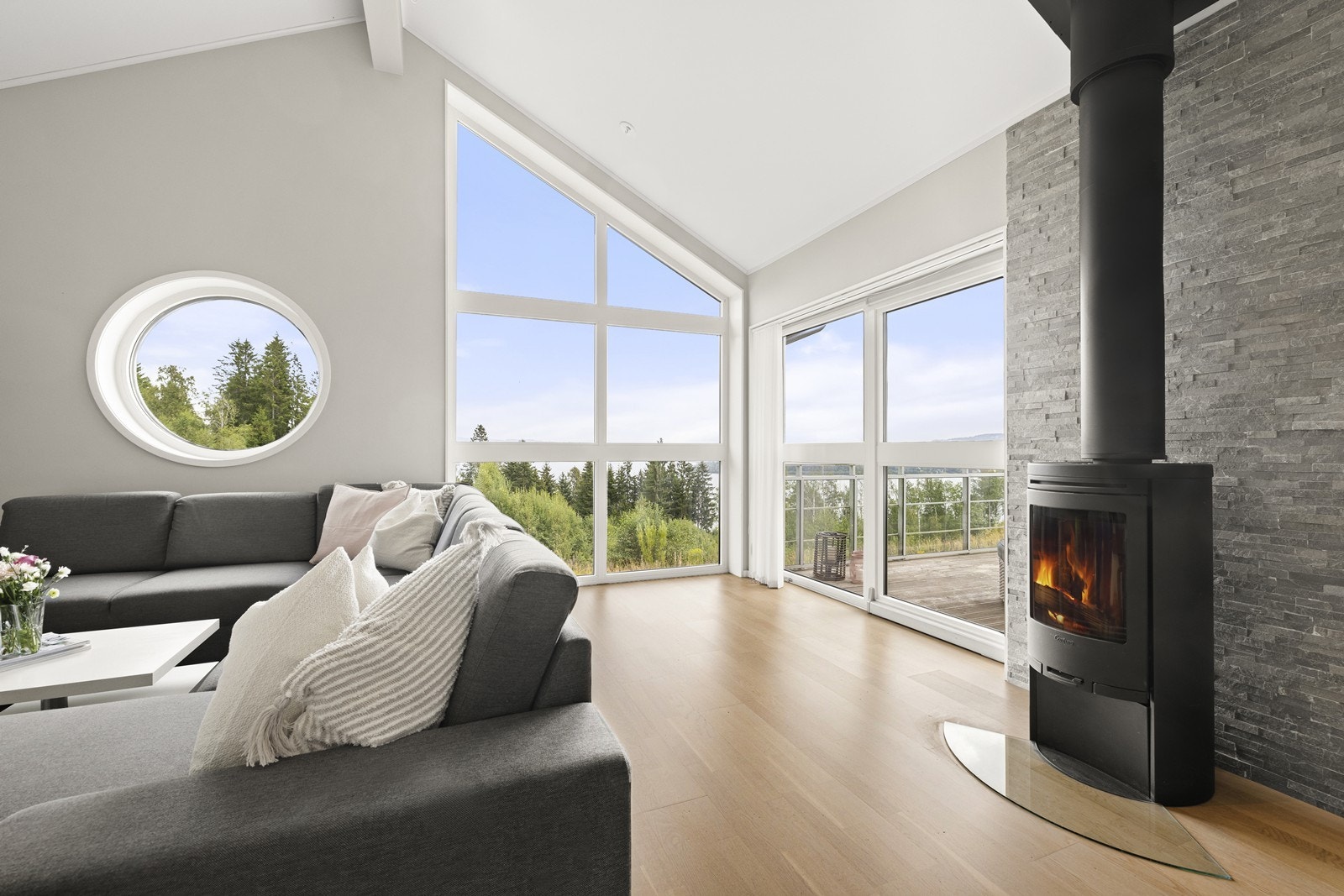 Stilig belysning, sammen med lysmalte overflater og peisovn, gir rommet det lille ekstra - og her vil en enkelt kunne føle seg hjemme. Galleribilde