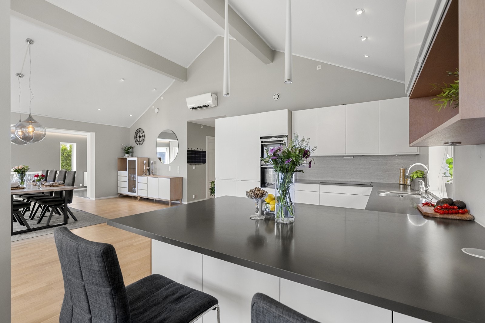 Moderne kjøkken i åpen løsning med stue og med smart barløsning som en naturlig avdeler. Galleribilde