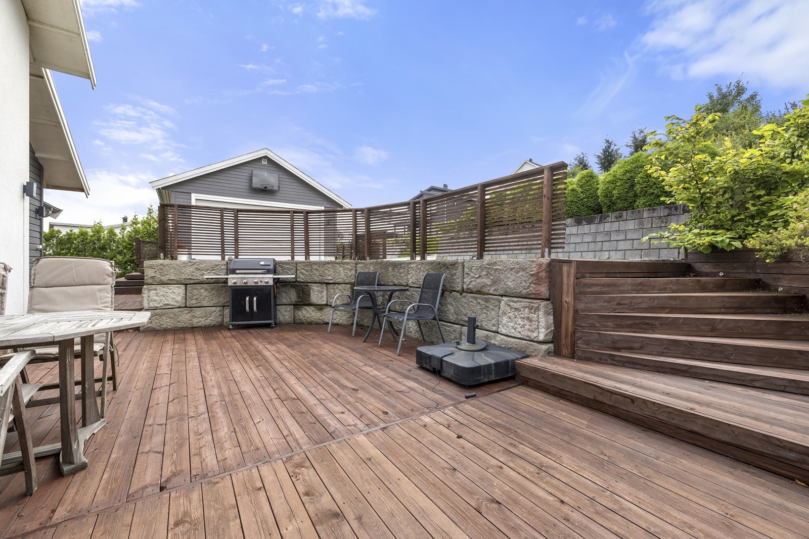 Usjenert uteplass rammet inn av en solid forstøtningsmur i naturstein. Galleribilde