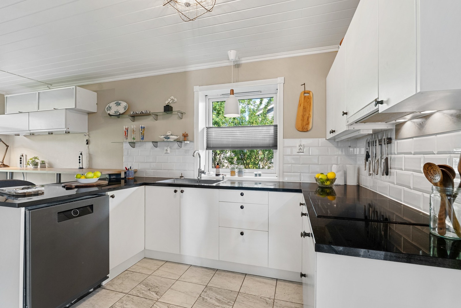 Kjøkkeninnredning med glatte fronter og benkeplate i granitt. Galleribilde