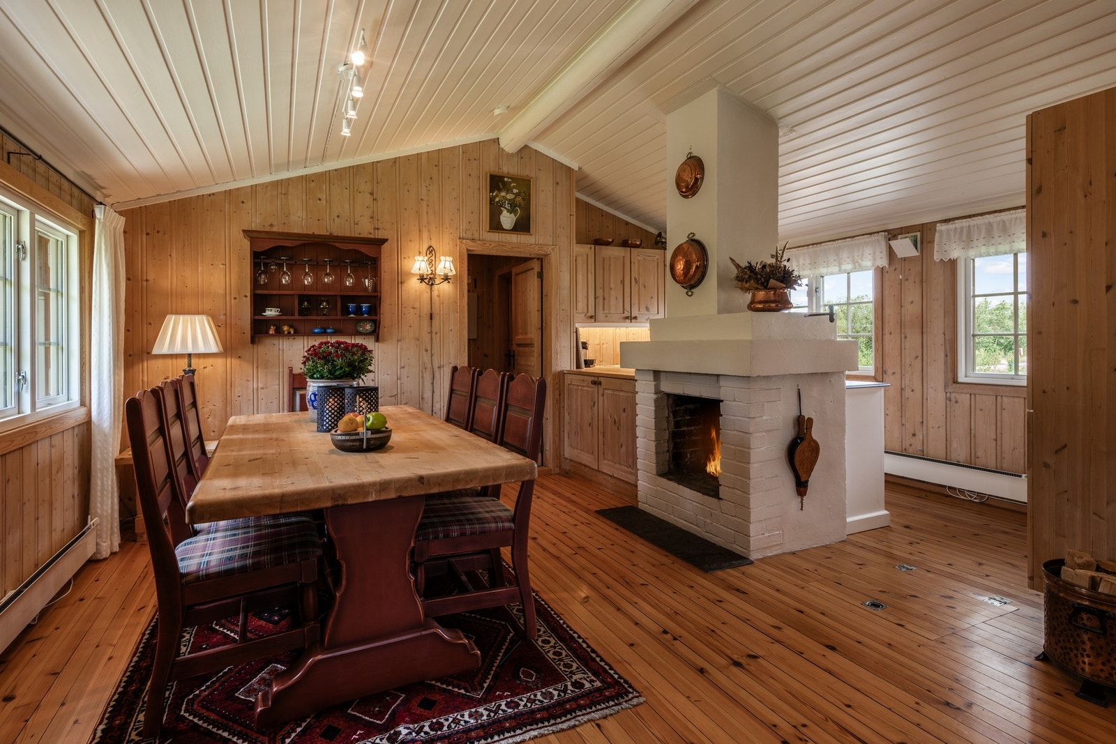 Åpen spisestue og kjøkken med en koselig peis som varmer godt på kalde vinterdager Galleribilde