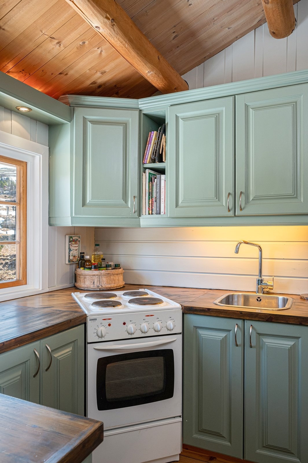 Servant er nedfelt i benkeplate. Det er komfyr og kjøleskap/frys. Galleribilde