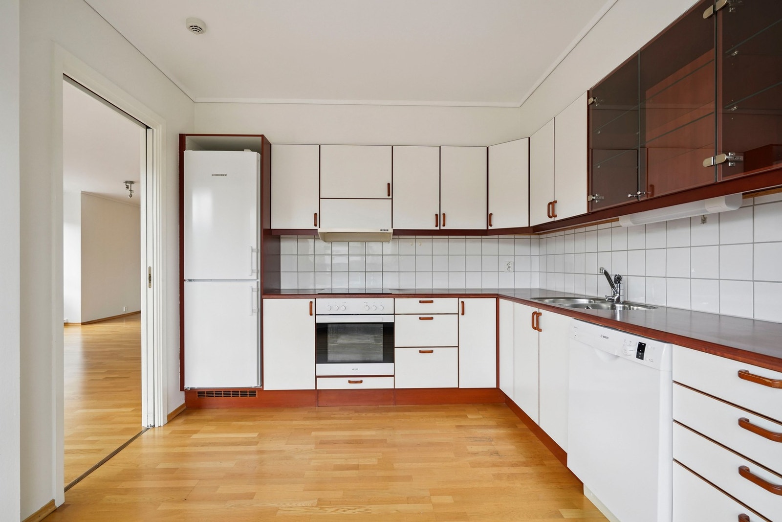 Kjøkken med innredning i glatte fronter og laminatbenkeplate. Utstyrt med kjøl/fryseskap, oppvaskmaskin, platetopp og stekeovn. Galleribilde