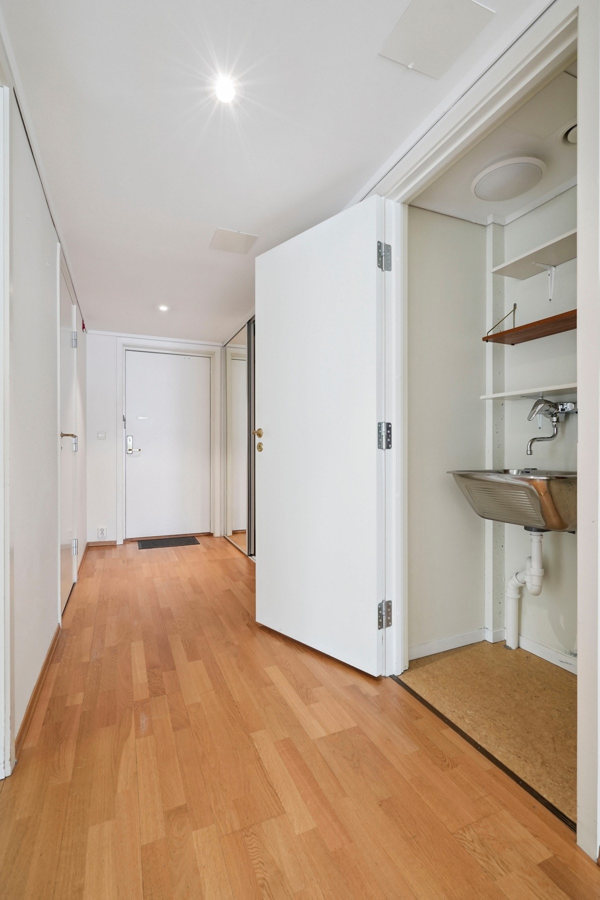 Praktisk bøttekott i gangen med utslagsvask, samt god plass til vaskemopper, støvsuger og andre rengjøringsartikler. Galleribilde