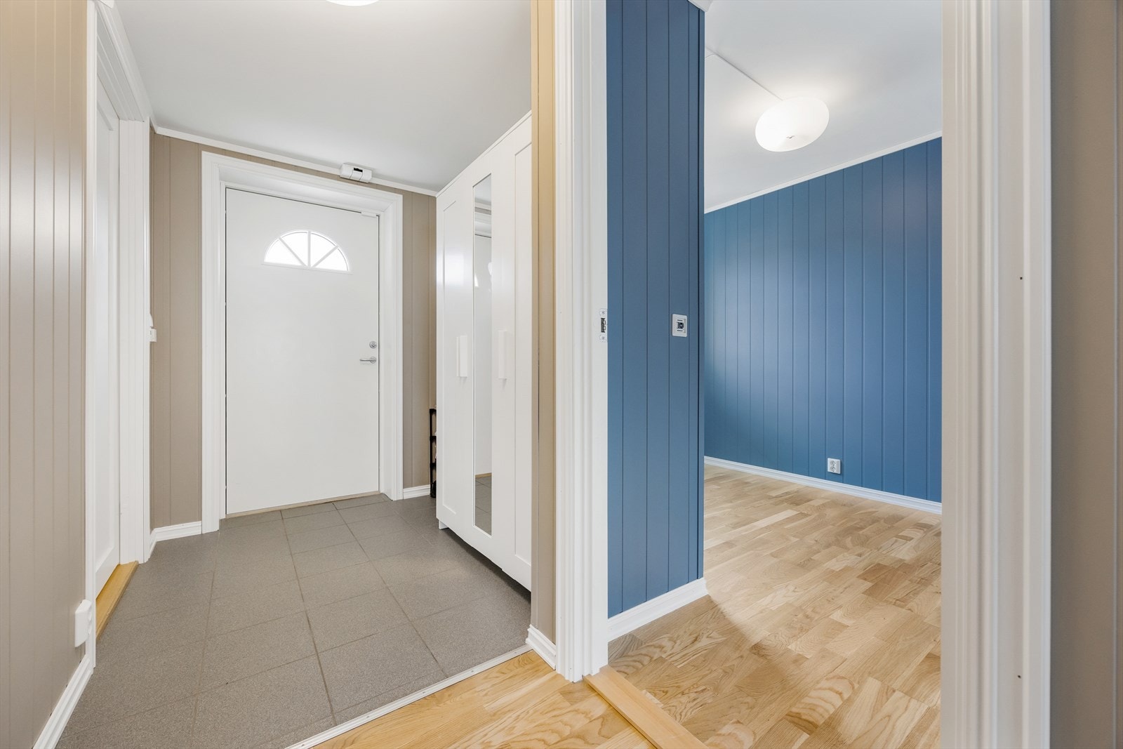 Hyggelig entré med flislagt gulv og panelte overflater. Galleribilde