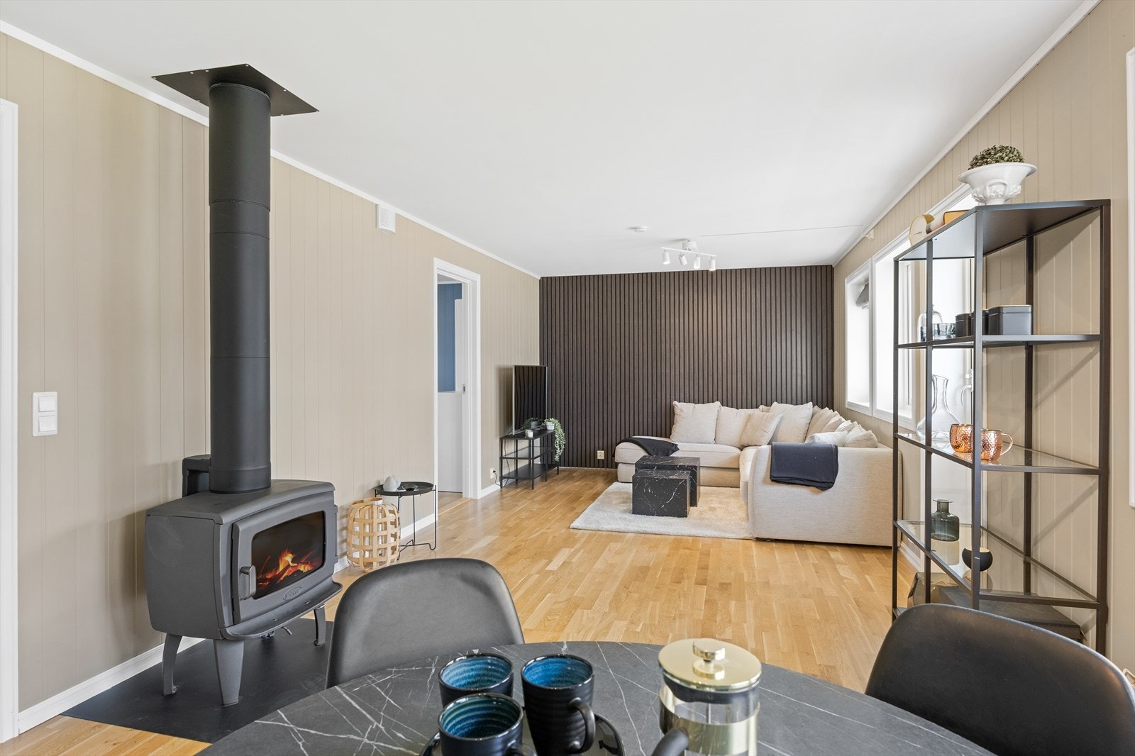 Lys og luftig stue med lysmalt panel og utgang til terrasse. Galleribilde