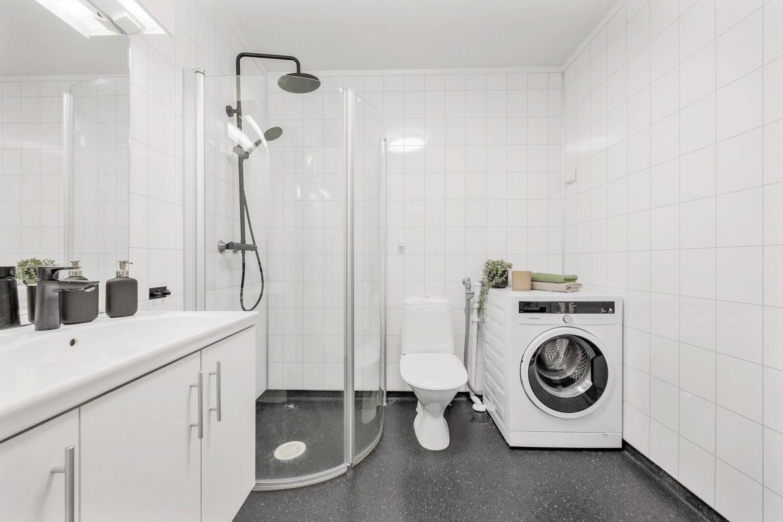 Badet er utstyrt med toalett, servant med skap og dusjnisje med innfellbare glassdører. Galleribilde