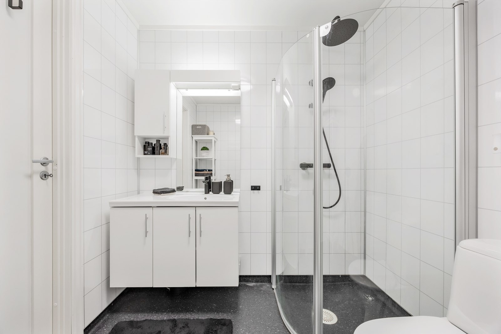 Pent baderom med belegg på gulv og våtromsplater på vegg. Galleribilde