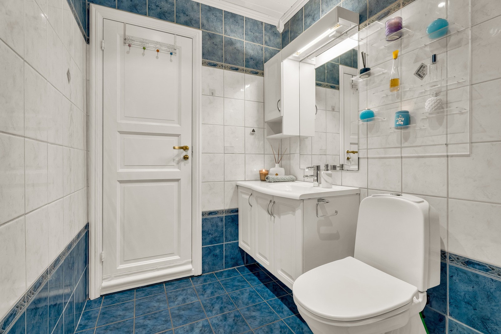 Badet har servantinnredning med skuffer, gulvstående toalett og dusjkabinett Galleribilde