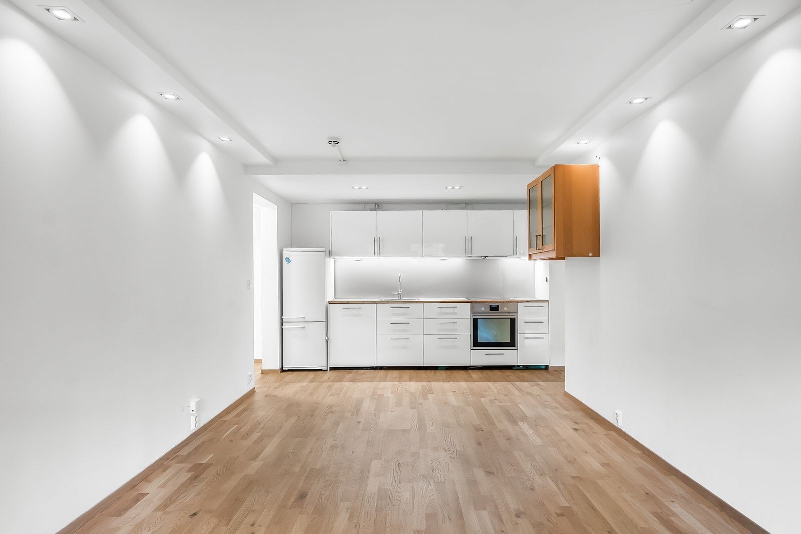 Stue og kjøkken i ett. Moderne kjøkken og himling med innfelte downlights. Galleribilde