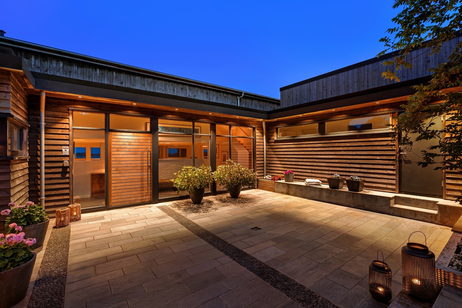 Skiferlagt atrium med inngangsparti, og varme i gangbane og trapp til innkjørsel.