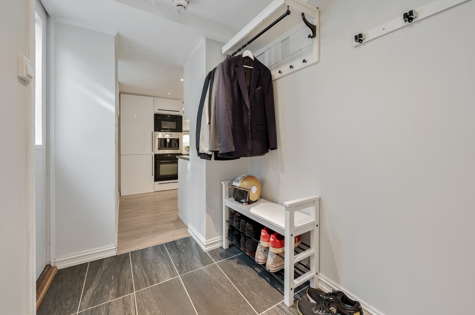 Velkommen inn i en praktisk entré med flislagt gulv og plass til å henge fra seg yttertøy. Galleribilde