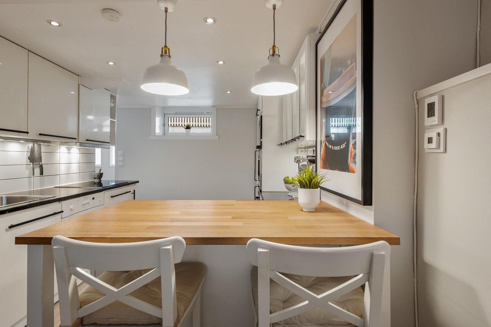 Den praktiske benkeløsningen med sitteplasser fungerer både som ekstra arbeidsflate og en mer uformell spiseplass. Galleribilde