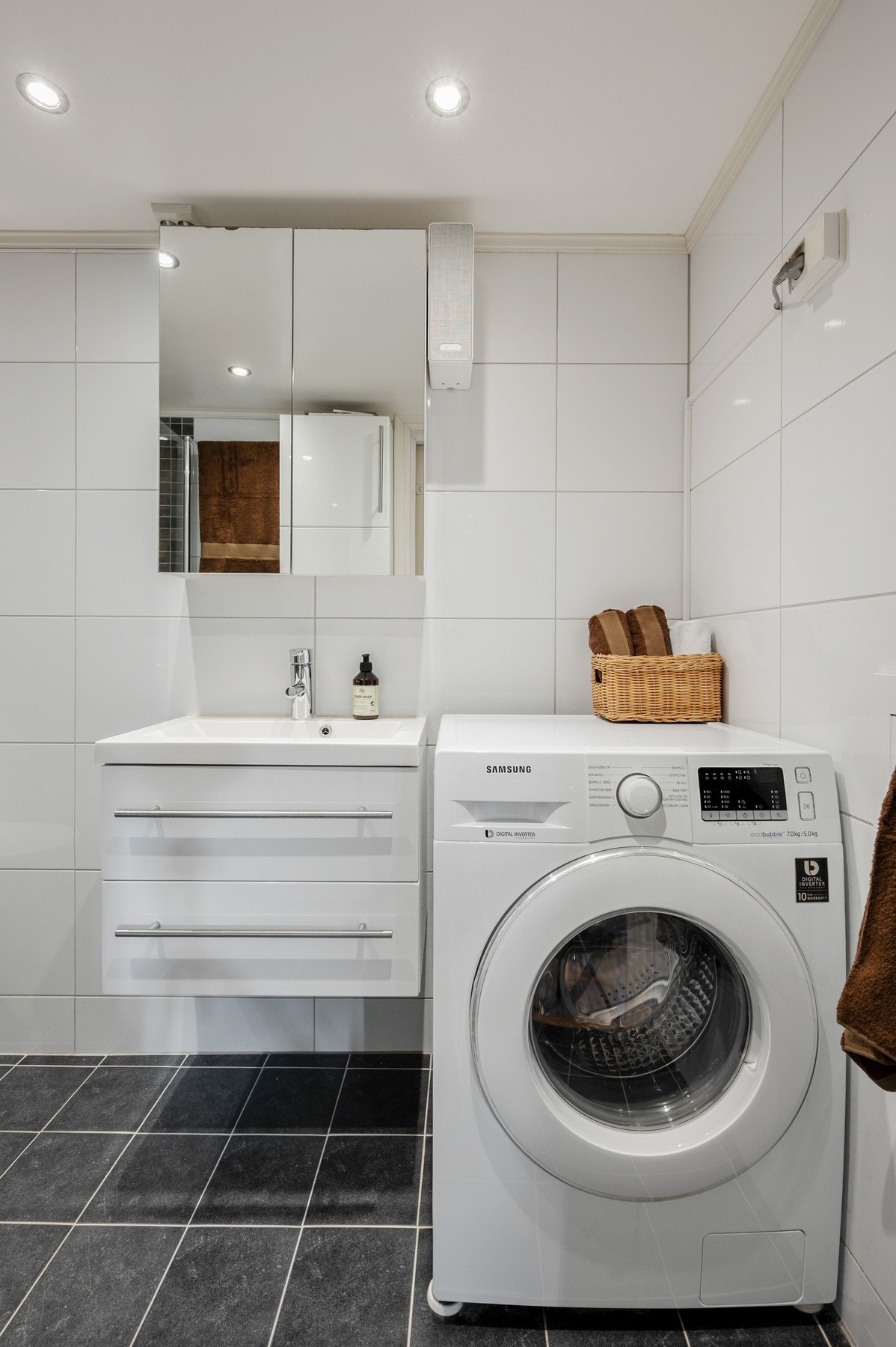 Badet har opplegg for vaskemaskin og godt med oppbevaringsplass i både speilskap og baderomsinnredning. Galleribilde