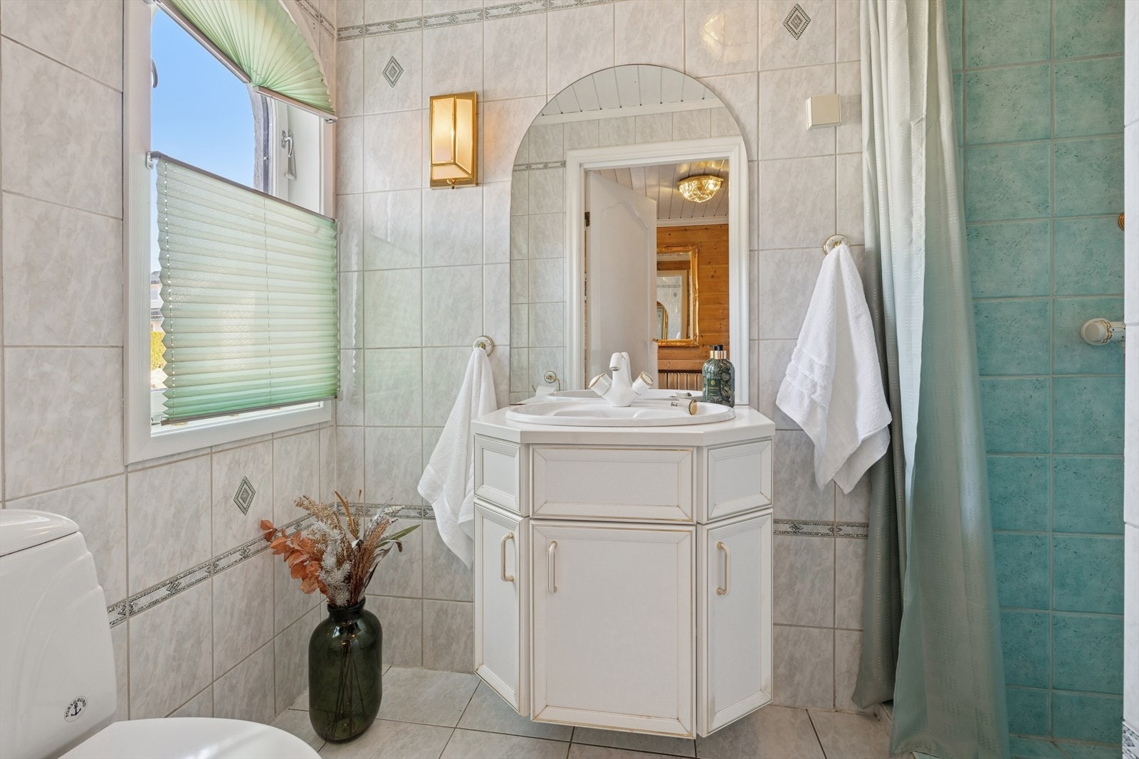 Flislagt baderom med gulvvarme, utstyrt med toalett, dusjnisje med forheng, samt baderomsinnreding med servant. Galleribilde