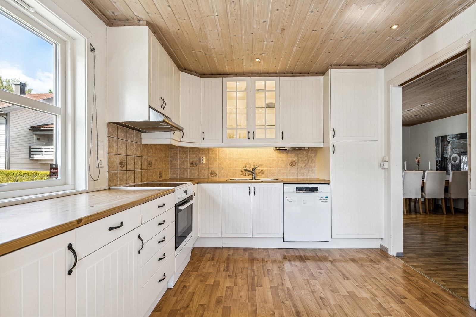 Stilrent og moderne kjøkken med hvitevarer og store vinduer som gir rikelig med dagslys. Galleribilde