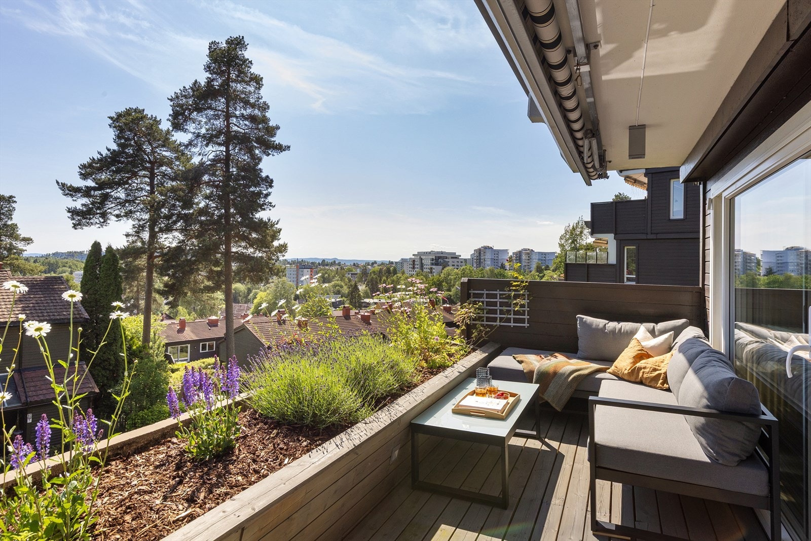 Lun og skjermet uteplass med hyggelig bed og markise. Galleribilde