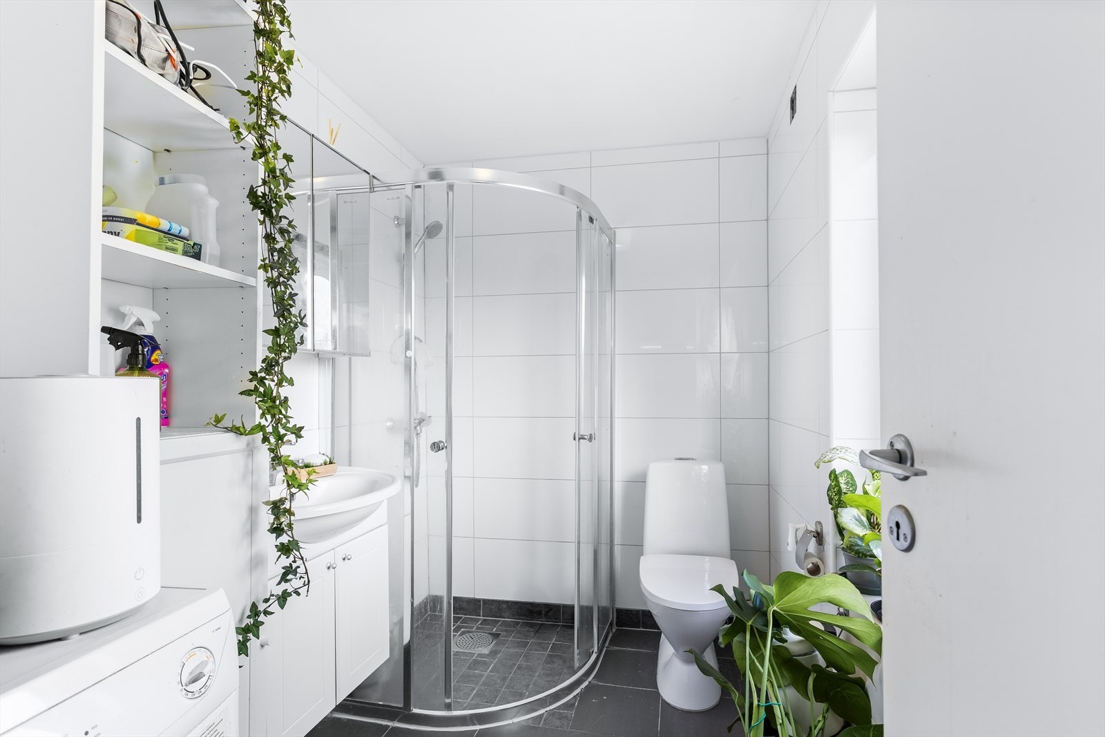 Bad fra 2011 med flislagt gulv, flislagte vegger og en himling med malt flate. Galleribilde