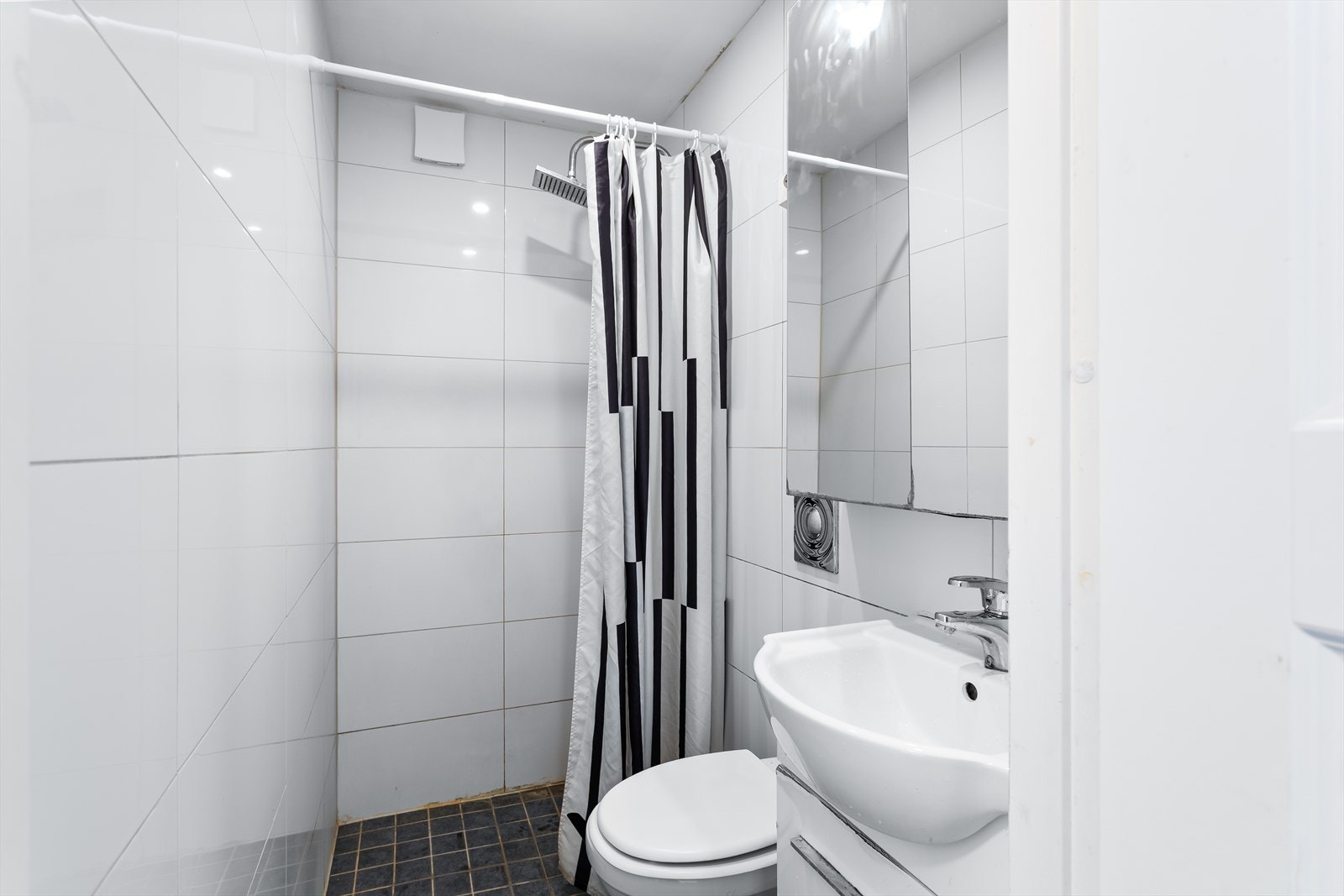 Bad fra 2011 med flislagte overflater og downlights. Galleribilde