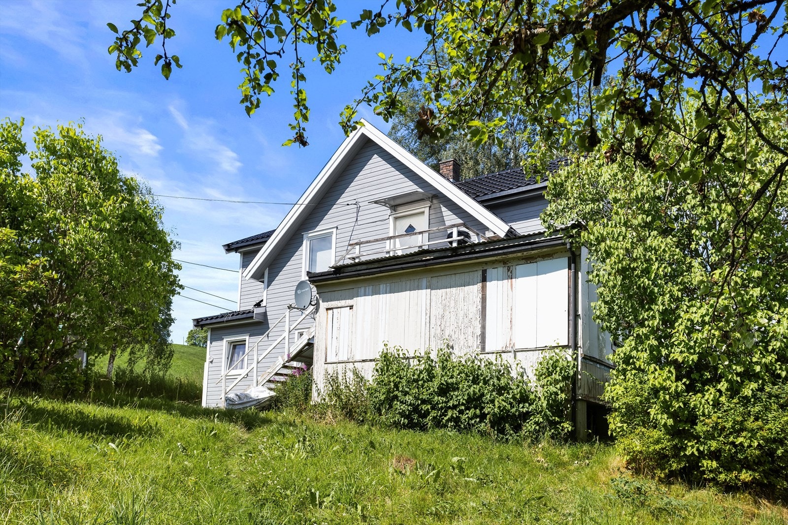 Eiendommen ligger skjermet og grønt til, med en frodig hage. Galleribilde