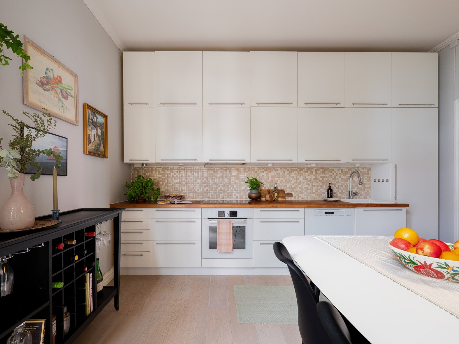 Innredningen har lyse fronter, fliser og belysning over x-finér benkeplate med nedfelt oppvaskkum m/ bl.batteri. Galleribilde