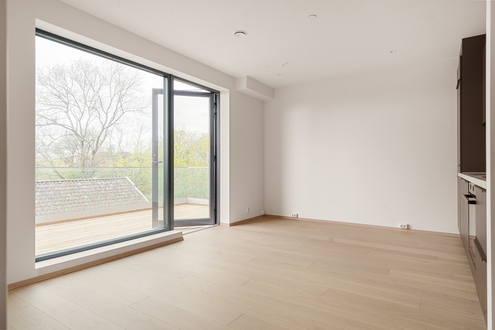 Åpen løsning mellom stue/kjøkken med store vindusflater Galleribilde