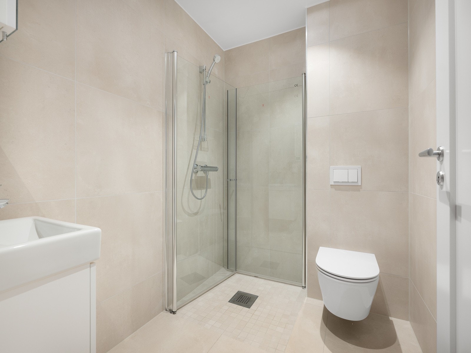 Baderom 2, dusj med svingbare dører, vegghengt toalett og baderomsmøblement. Speil med hylle. Galleribilde