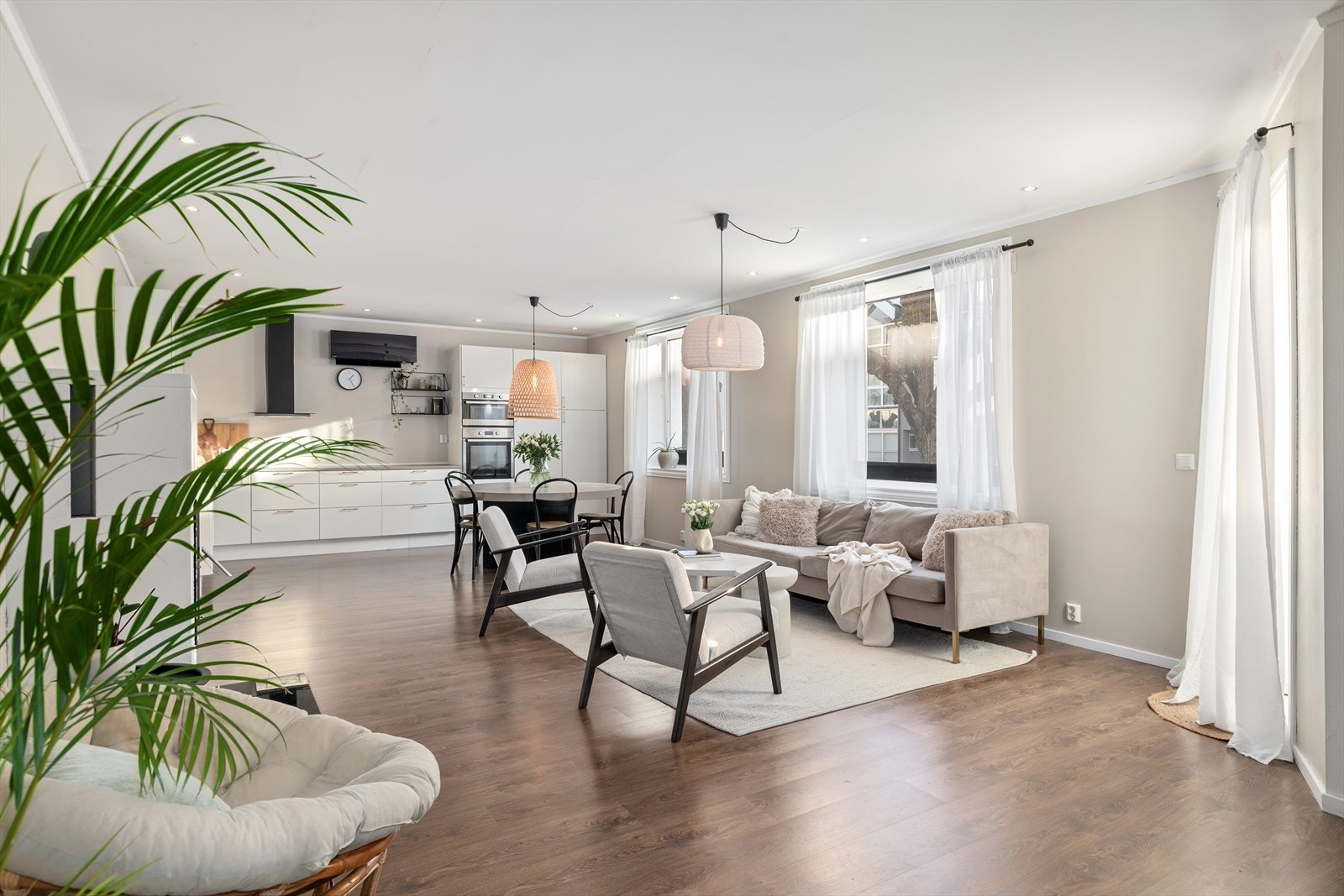 Videre inn fra gangen er det en romslig stue med åpen kjøkkenløsning Galleribilde