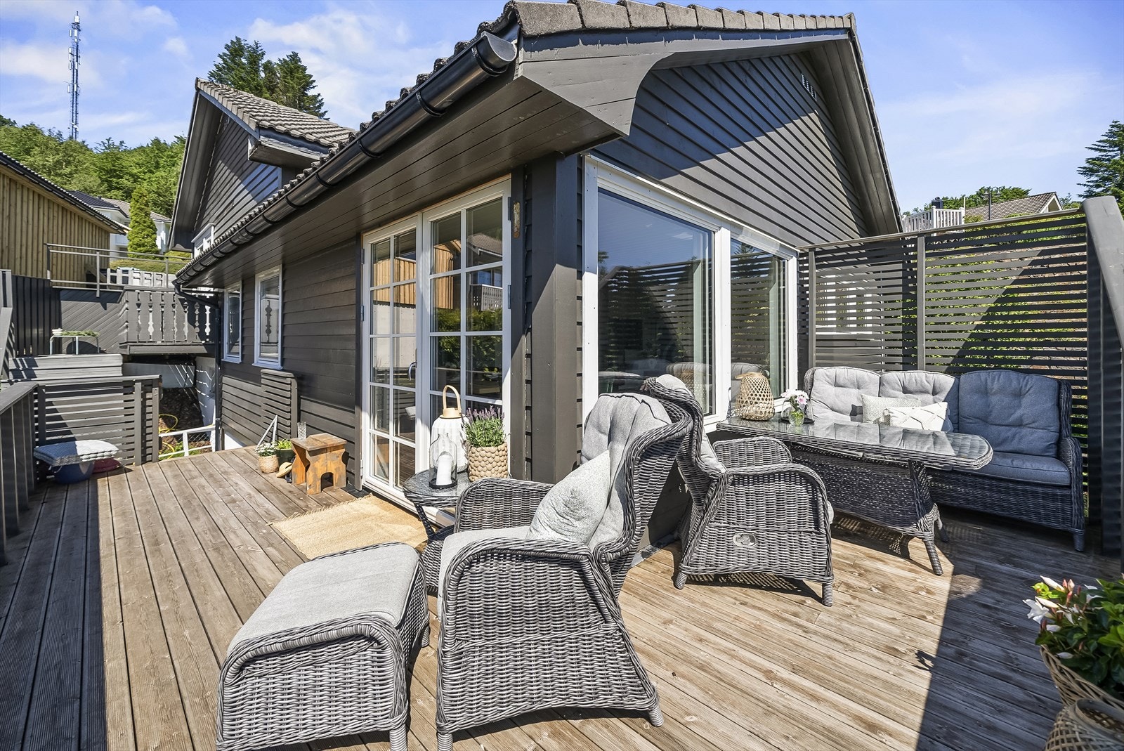 Solrik uteplass med utgang fra stua og nedgang til hagen. Galleribilde