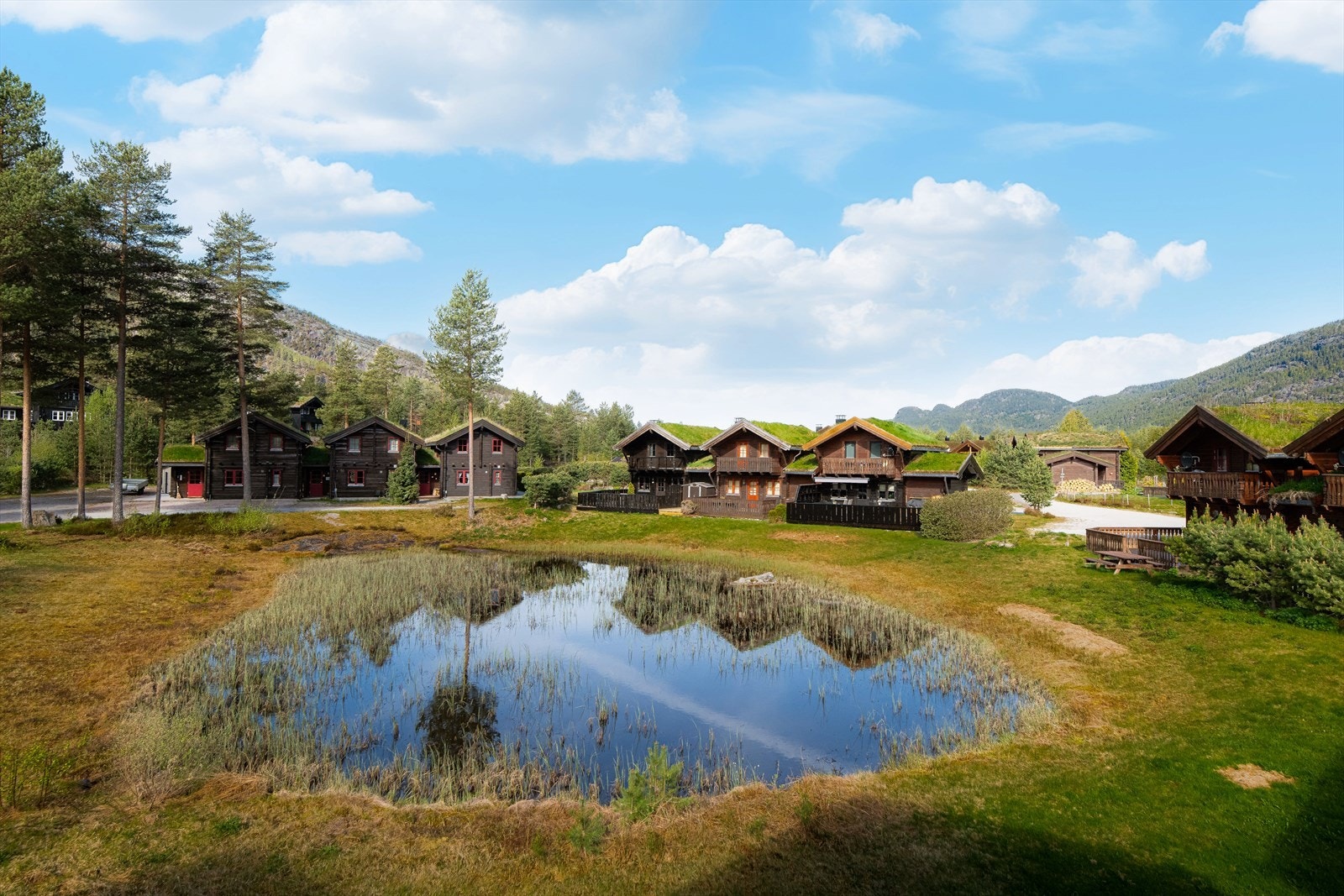 Tomten er opparbeidet med internveger, plenarealer og et lite tjern mellom bebyggelsen. Galleribilde