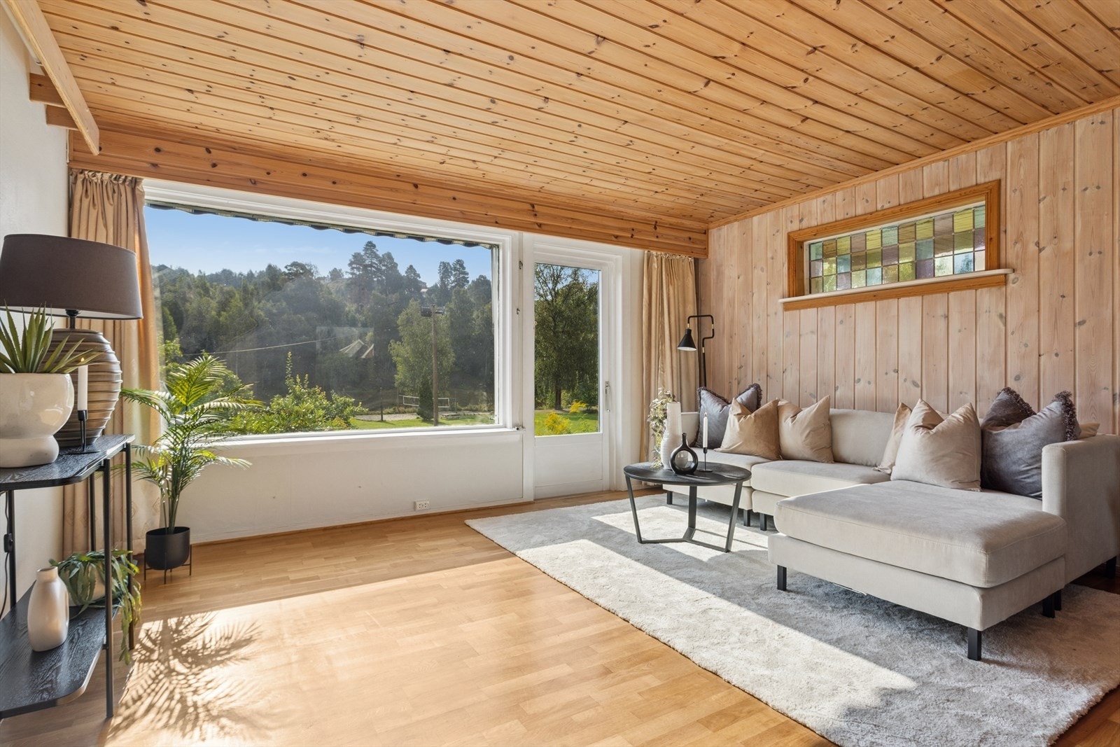 Stuen har mye lys og dør ut til hage. Galleribilde