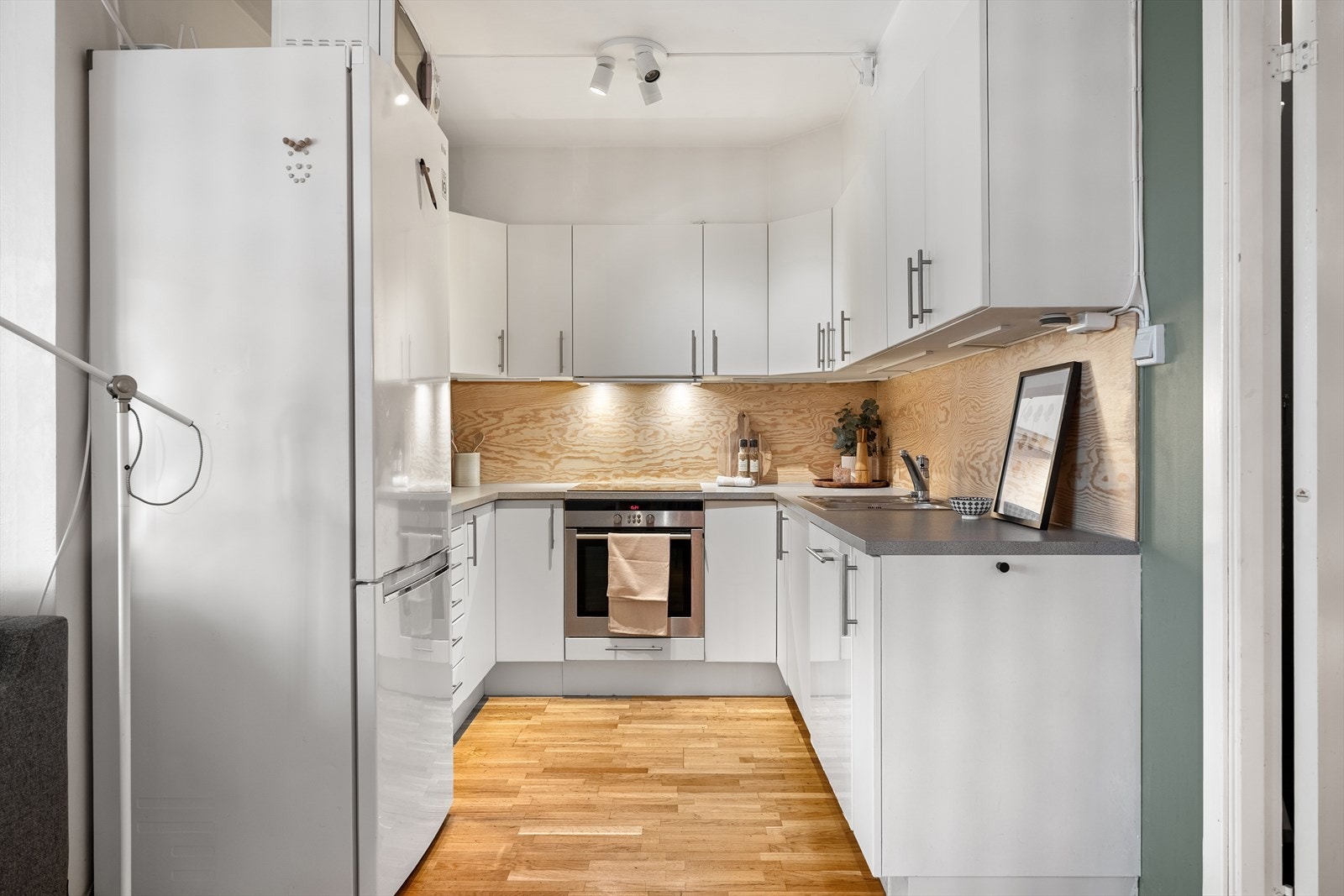 Kjøkken i en u-form med godt med skap og benkeplass Galleribilde