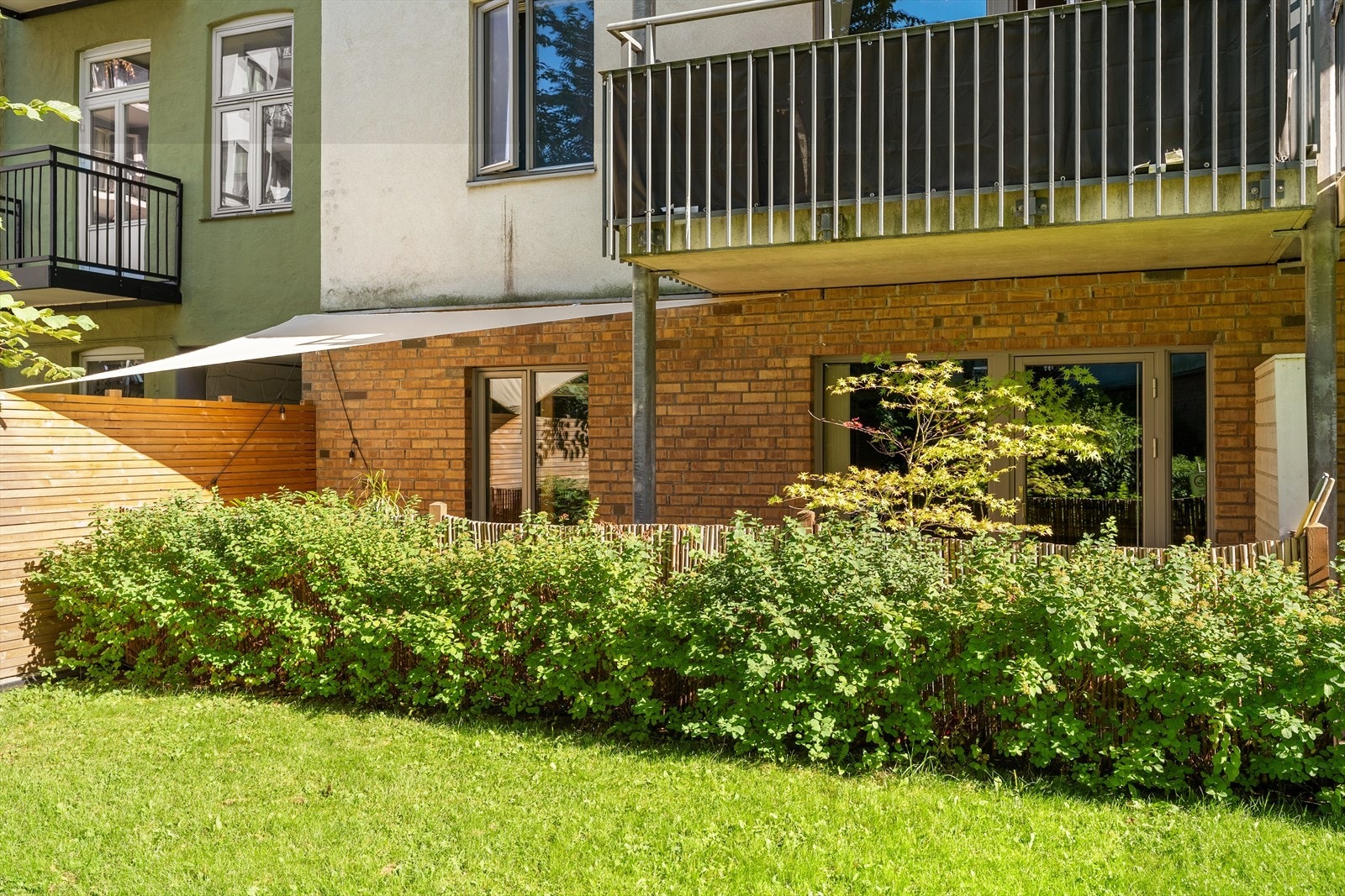 Terrassen er skjermet med busker og levegg i bambus Galleribilde