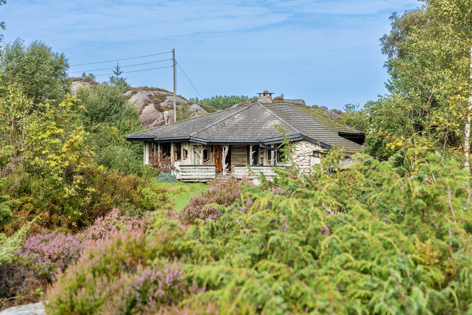 Hyttens materialvalg gjør at den glir naturlig inn i omgivelsene. Galleribilde
