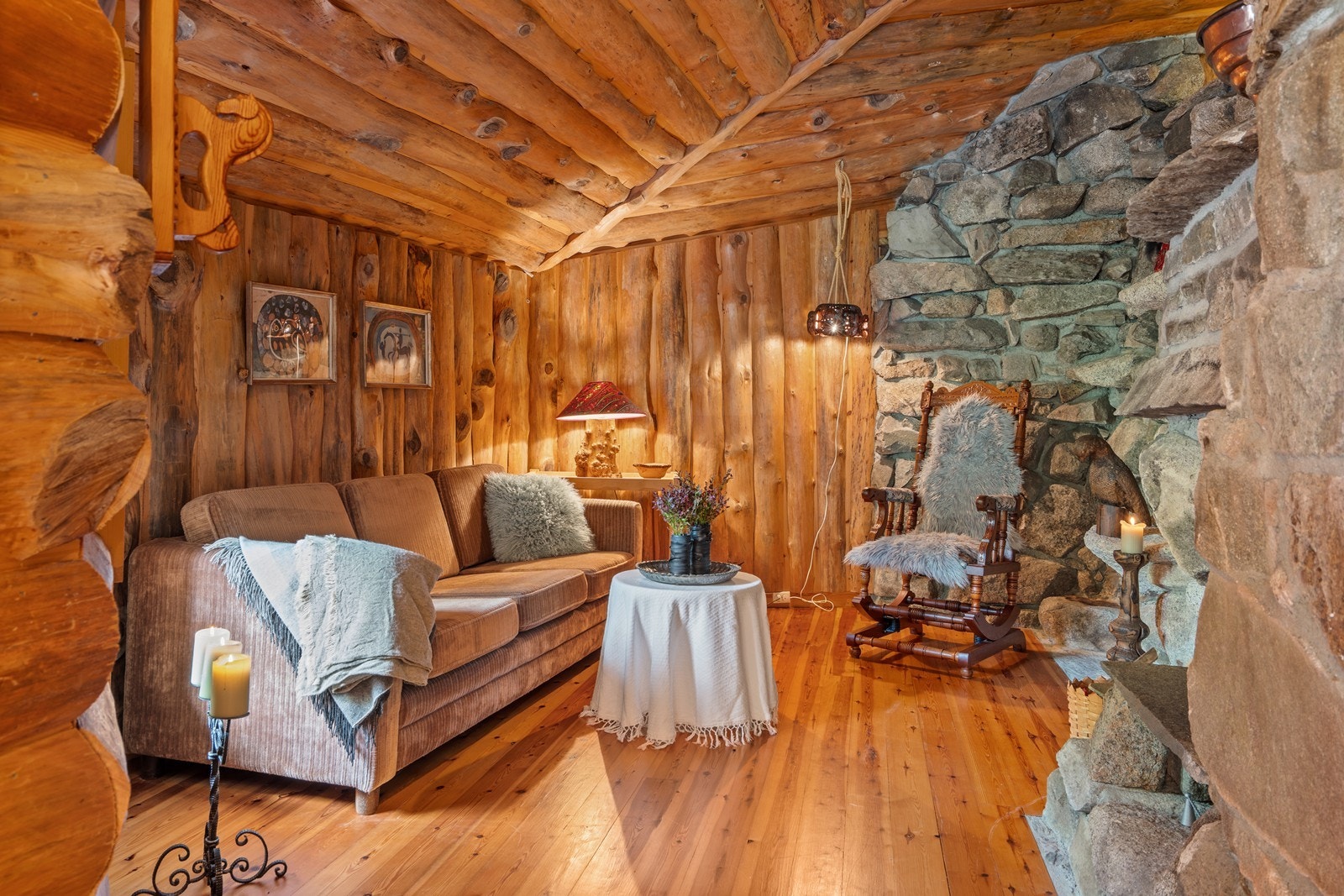 Koselig peisestue med vakker naturstein rundt peis og på deler av vegg. Galleribilde