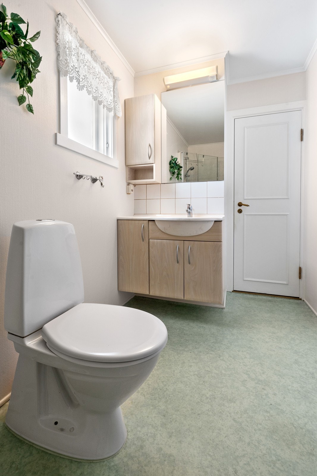 Rommet har skapinnredning med nedfelt servant og med speil over servant, gulvmontert wc og elektrisk styrt vifte. Galleribilde