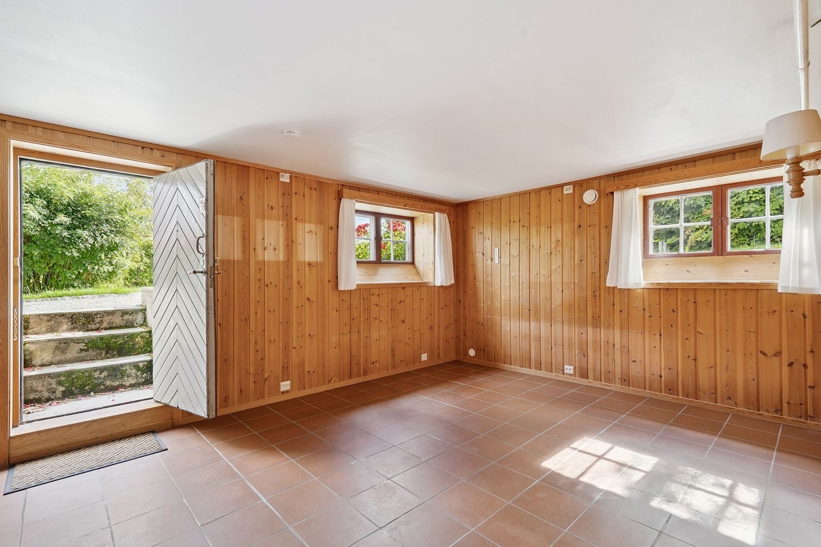 Romslig kjellerstue på ca. 18 m² med peis og gulvvarme, med enkel utgang til hagen. Galleribilde