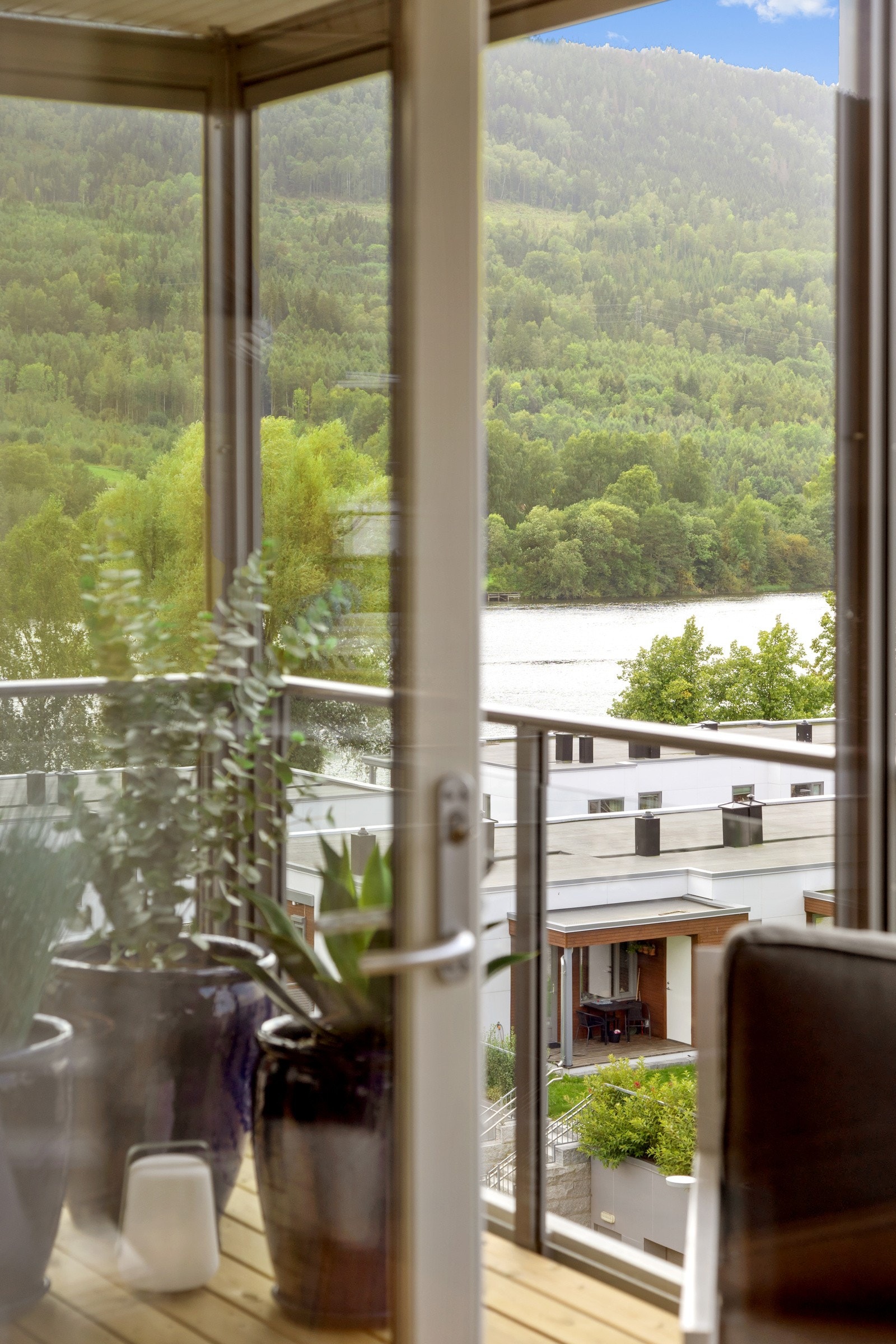 Flott utsikt fra stuevinduene mot elva | balkong med rekkverk av metall og glass | downlights i overbygget Galleribilde