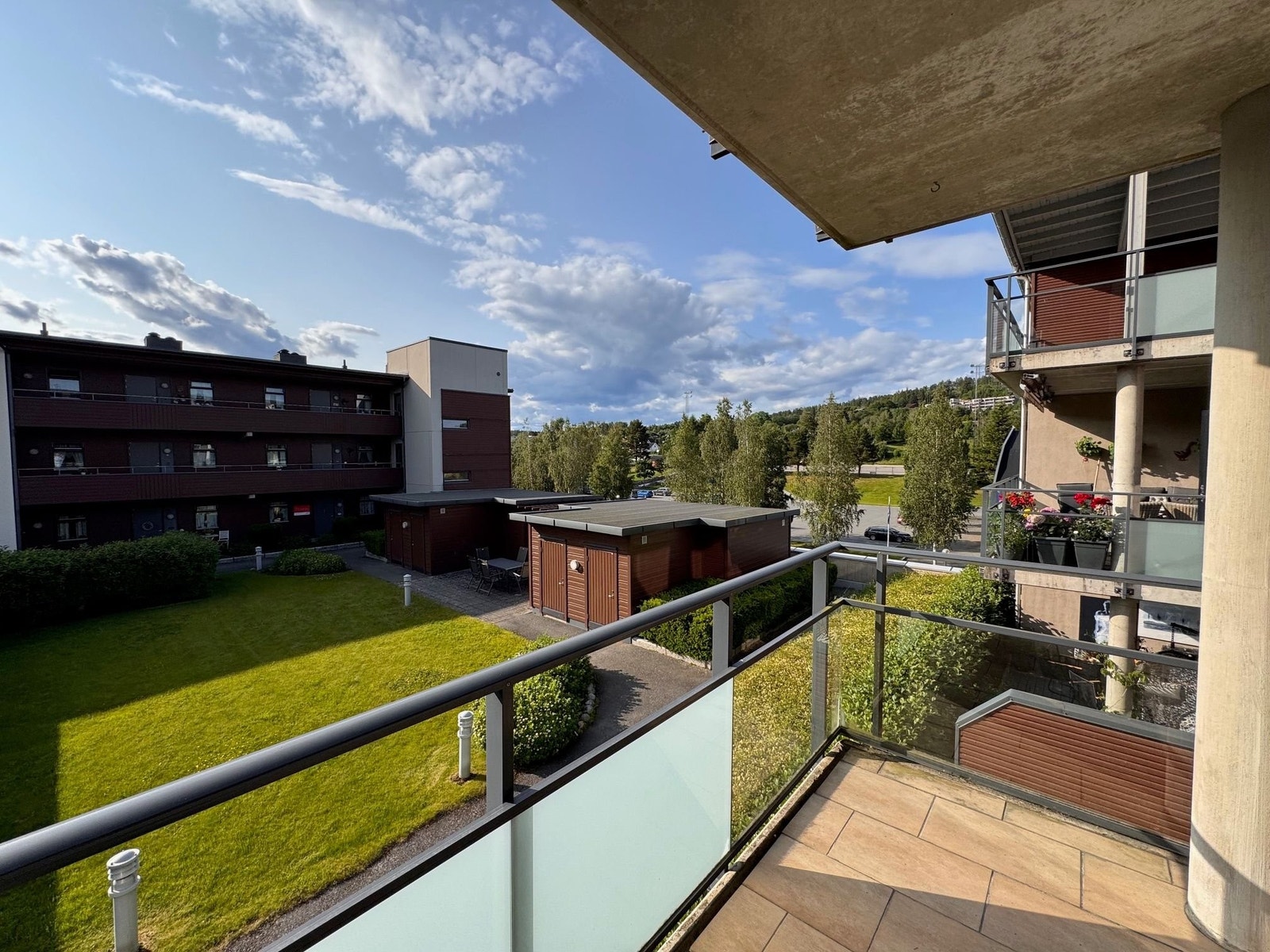 Fra balkong er det utsyn mot vest og ned på fellesarealene på platået i 2.etg mellom blokkene. Galleribilde