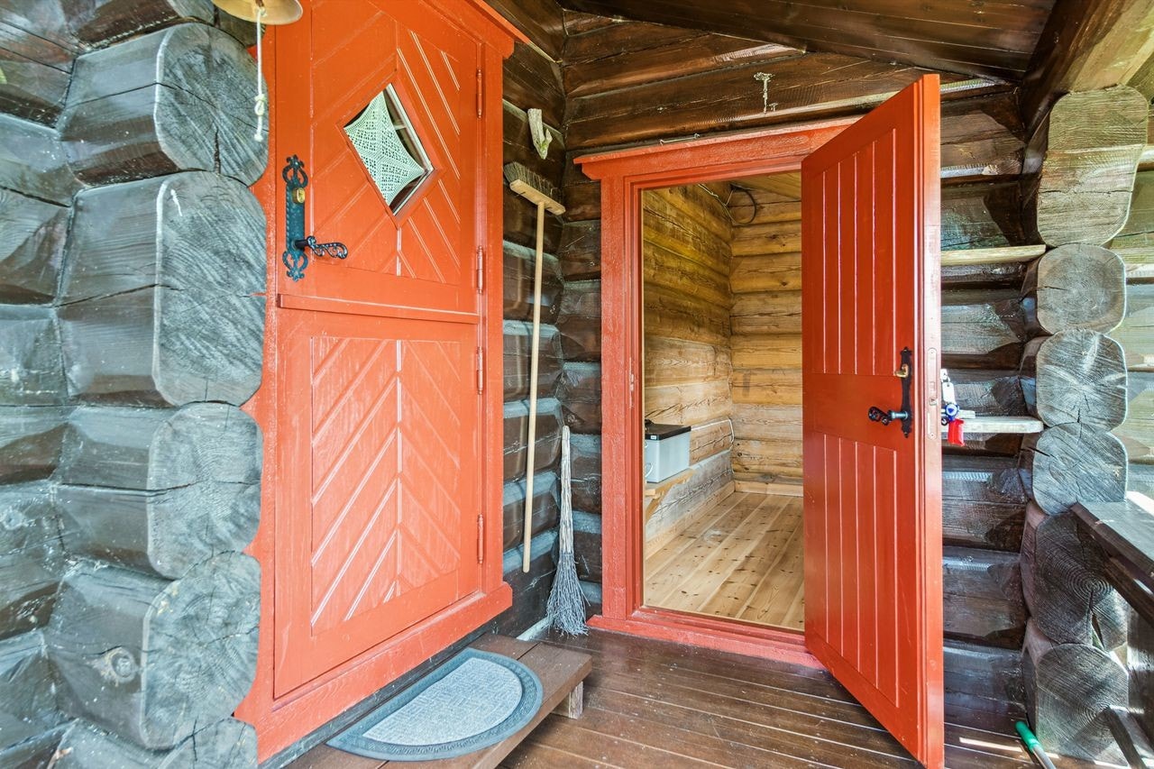 Adkomst til hytta via et overbygget inngangsparti som leder inn til en praktisk entré. Galleribilde