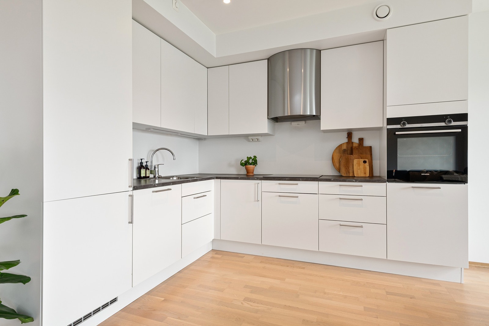 Kjøkkeninnredning fra kvalitetsleverandøren HTH med hvite fronter og integrerte hvitevarer. Galleribilde