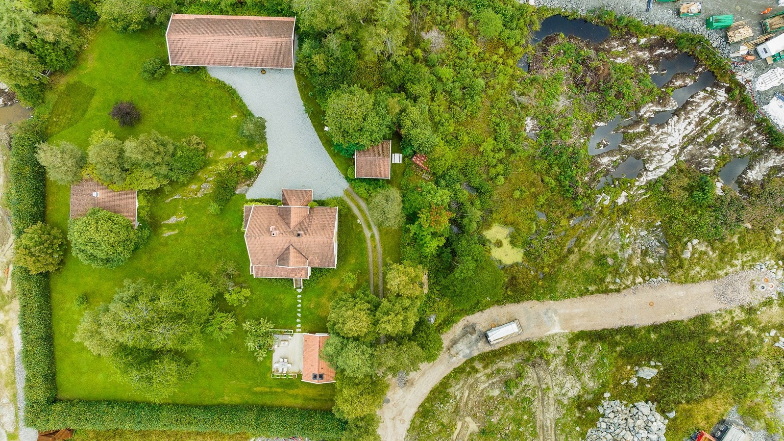 Oversiktsbilde. Stallen er helt til venstre i bildet. Stallen kan også være fint for alternativt bruk som verksted eller lignende. Legg ellers også merke til at tunet og hagen er omkranset og skjermet av beplantning og hekk Galleribilde