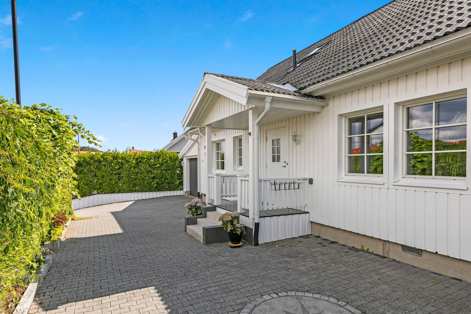 Det er pent opparbeidet inngangsparti med steinbelagt gårdsplass, og inngangsparti med overbygg. Galleribilde