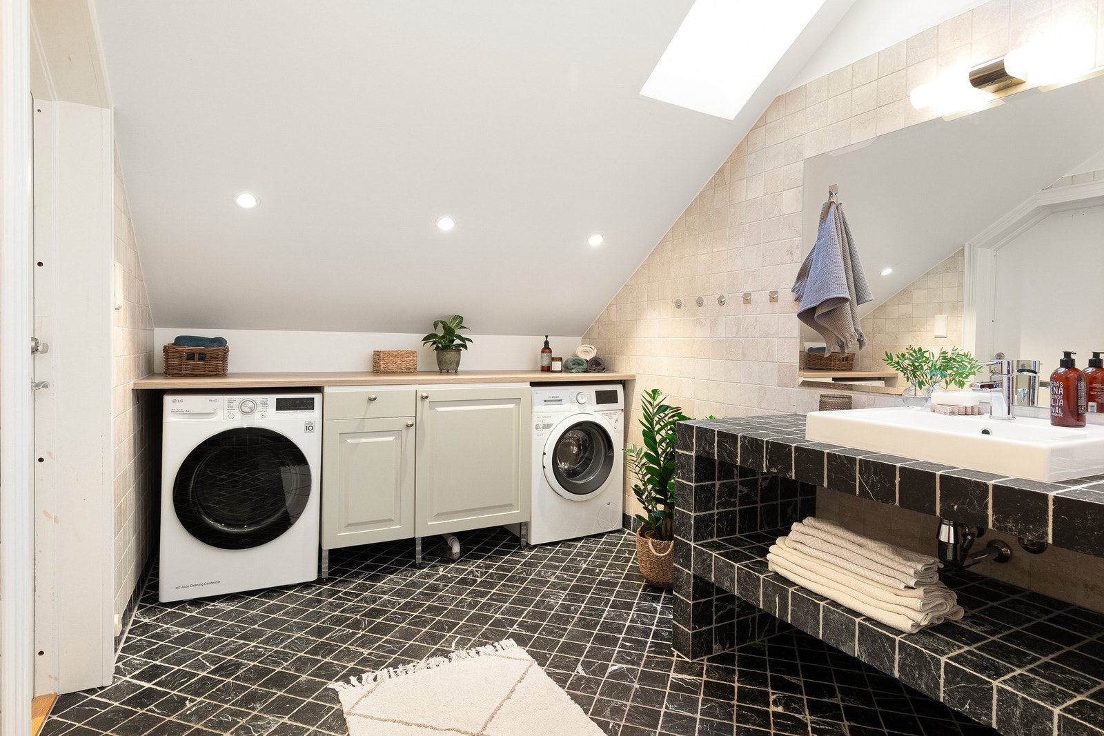 Badet er innredet med benkeskap og tilhørende benkeplate med plass til både vaskemaskin og tørketrommel under. Galleribilde